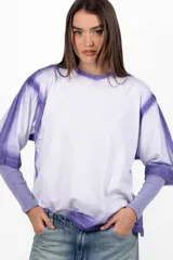 Remera blanca de mangas cortas con cuello redondo y ruedo con efecto tie-dye en color violeta.