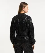 Campera bomber corta negra cubierta de lentejuelas metalizadas, con cuello alto, mangas largas, puños y bajo elásticos, y cierre frontal con cremallera.