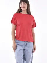 Remera roja de manga corta con cuello redondo. Presenta un canesú en la parte superior de las mangas y el pecho con textura acanalada, mientras que el cuerpo es liso.