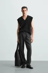 Chaleco negro de punto con cuello en V y sisas.