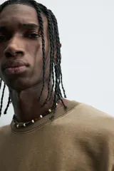 Camiseta color beige de corte holgado, cuello redondo y manga corta.