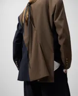 Blazer bicolor con manga larga, solapa, cierre de un botón y bolsillos de vivo en delantero.