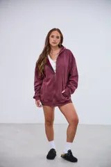 Cardigan con capucha color bordó, con cierre frontal, efecto lavado y bolsillos delanteros.