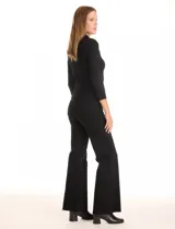 Buzo de punto acanalado color beige, con cuello polo y cierre de botones en el escote. Manga tres cuartos.