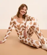 Conjunto de pijama canelado blanco con estampado de corazones marrones. Incluye blusa de mangas largas y pantalón con cintura elástica y puños ajustados.