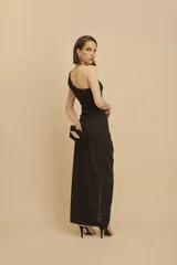 Vestido largo de fiesta negro, con un solo hombro y tajo en la pierna.