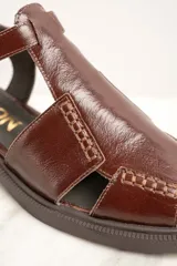 Sandalias de cuero marrón con diseño de tiras cruzadas y hebilla lateral.