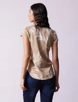 Remera de modal color beige con estampado de hojas blancas, cuello redondo y mangas cortas.