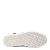 Zapatillas deportivas acordonadas color beige con suela marrón.