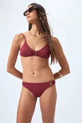 Bottom de bikini color borgoña con textura y detalle de aro en uno de los laterales.