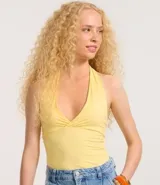 Top corto frente única color amarillo, confeccionado en microfibra sin estampa, con breteles anchos y escote V cruzado.