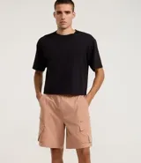 Bermuda masculina de poliéster, corte baggy, con cintura elástica ajustable con cordón y bolsillos cargo con cierre de cremallera.
