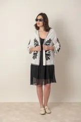 Saco color crudo de lino y viscosa con bordado de hilo de seda negro, de corte suelto y mangas tres cuartos.