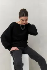 Sweater negro tramado de silueta relajada, con combinación de texturas en el tejido y mangas abullonadas con puños elastizados.