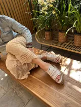 Sandalias blancas de cuero con plataforma de madera y goma. Presentan tachas color cobre en las tiras. Hechas a mano en Uruguay.