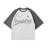 Remera blanca de corte oversize con mangas cortas grises tipo ranglán y estampado frontal con el texto "Venefo Club" en gris.