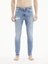 Jeans skinny de tiro bajo, color azul claro vintage con efecto desgastado y rotos en las piernas.