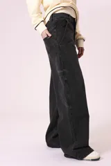 Pantalón de jean negro de corte ancho, con bolsillos laterales y traseros.