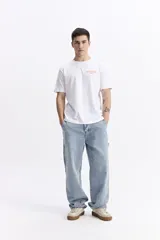 Remera blanca de manga corta con escote redondo y estampado frontal en color naranja que dice "NO RULES!".