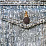 Campera de denim azul con estampado de la palabra "Fuck" repetida en toda la prenda. Tiene cuello clásico, cierre con botones metálicos, dos bolsillos con solapa en el pecho y puños abotonados.