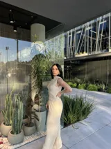 Musculosa color beige con cuello alto y diseño plisado.