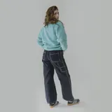 Pantalón negro de gabardina, corte recto y tiro alto, con costuras blancas a contraste.