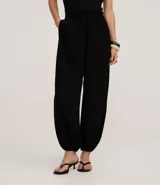 Pantalón de mujer color marrón oscuro, estilo balloon o bombacho, con cintura y puños elásticos.