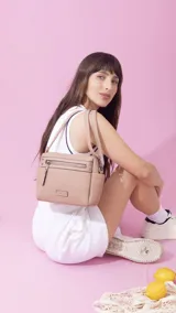 Bandolera color beige con correa extensible, cierre principal y bolsillos interiores, un bolsillo frontal, un bolsillo posterior y bolsillos laterales.