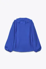 Camisa azul con escote en pico, cierre frontal con botones, mangas largas abullonadas con elástico en los puños y detalle de volantes en el frente.