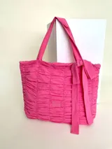 Bolso tipo tote color fucsia, 100% algodón, con diseño drapeado, moña fija y grifa de acrílico Cilento.
