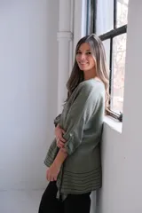 Blusa verde seco de lino, corte holgado, mangas 3/4 con botón y detalle de rayas horizontales en el ruedo.