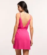 Vestido corto de viscosa color fucsia, con escote en pico delantero y trasero, breteles finos regulables y lazo lateral.
