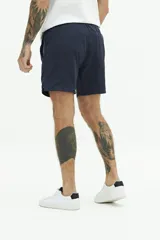 Short de baño liso color azul marino, con cintura elástica ajustable con cordón, dos bolsillos laterales, un bolsillo trasero y logo bordado.