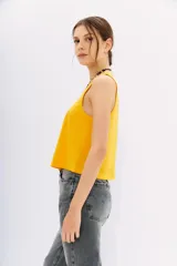 Musculosa amarilla de algodón con escote redondo pronunciado y corte holgado.