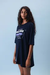 Remera azul marino de corte holgado con estampado frontal con la frase "Menos etiquetas, más amor" y cerezas.