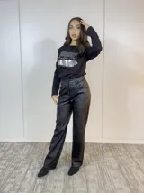 Pantalón negro de eco cuero, corte recto y tiro alto.