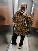Campera con capucha de tela tipo peluche color marrón con estampado animal print de leopardo en negro.
