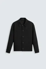 Sobrecamisa negra de corte cuadrado, con cuello solapa, manga larga con puños abotonados, bolsillos tipo parche en el pecho, bolsillos laterales y cierre frontal con botones.
