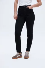 Pantalón de jean negro de tiro medio con calce ajustado desde la cintura hasta los tobillos.