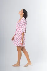 Bata kimono corta de algodón estampado con flores rojas, violetas y verdes. Tiene mangas al codo y lazo de ajuste en la cintura.