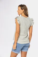 Remera color beige con estampado floral y volados en las mangas.