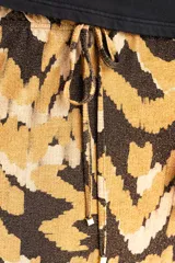 Falda midi de viscosa con estampado abstracto en tonos marrón, beige y negro. Tiene cintura elastizada con cordón ajustable y abertura lateral.