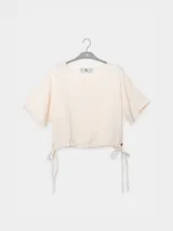 Top corto color crudo de lino tencel, con mangas cortas y lazo ajustable en el ruedo.