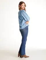 Blusa de lyocell color azul claro, con escote en V, detalles de costuras verticales en el frente y mangas tres cuartos con puños elastizados.