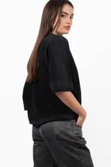 Remera blanca de mangas cortas con cuello redondo y ruedo con efecto tie-dye en color violeta.