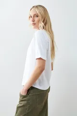 Remera color verde pistacho, de corte recto y manga corta raglán con detalle de vainillas en los hombros.