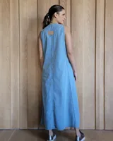 Vestido largo color crudo, sin mangas y con escote en V. Presenta aberturas laterales en el ruedo y bolsillos laterales a la altura de la cadera.