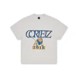 Camiseta gris de algodón pesado con logo Corteiz Alcatraz estampado en el pecho y diseño gráfico con un león y el año 2018 en la espalda.