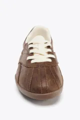 Zapatillas deportivas marrones con detalle de pespuntes en el corte y cierre mediante cordones a contraste de color blanco. Suela de 2,5 cm de altura.