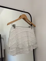 Minifalda blanca de encaje con volados y short interno.